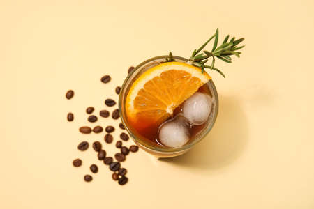 Glass of tasty coffee with orange juice on color background