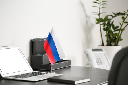 Russia flag, notebook, organizer and laptop on dark table near light wallの写真素材