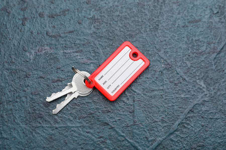 Keys with plastic tag on dark background