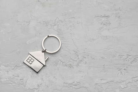 Stylish house shape keychain on gray background