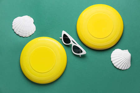 Flying disks, sunglasses and seashells on color backgroundの写真素材