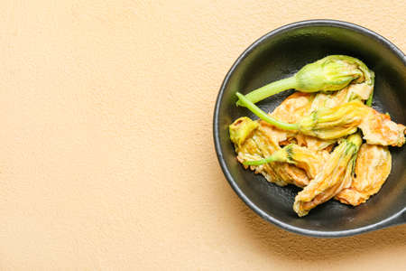 Frying pan with fried zucchini flowers on color backgroundの写真素材