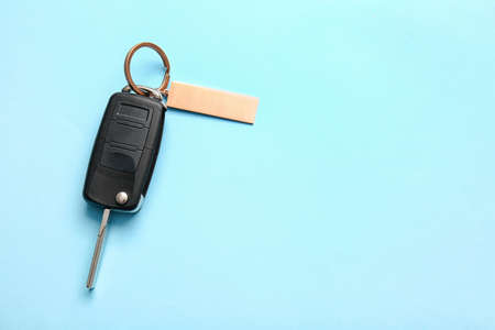 Car key with stylish keychain on color backgroundの写真素材