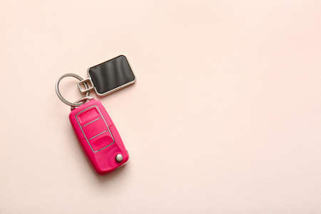 Car key with stylish keychain on light backgroundの写真素材