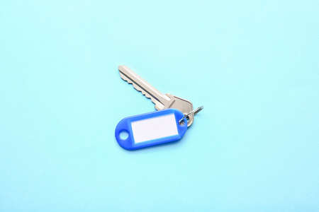 Plastic tag with key on color background