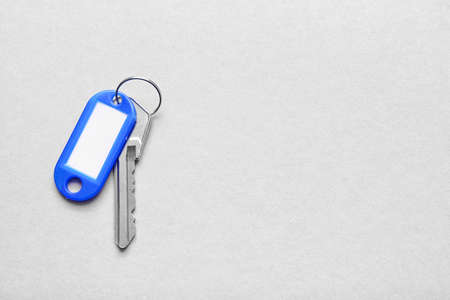 Plastic tag with key on light background