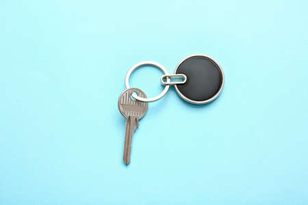 Key with stylish keychain on color background
