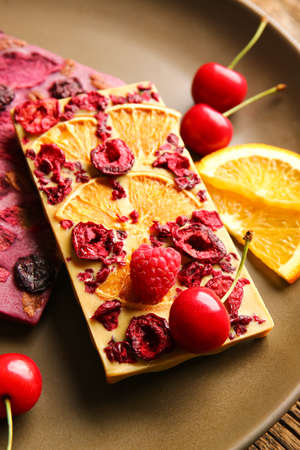 Handmade chocolate bars with fruits and berries on table, closeupの写真素材