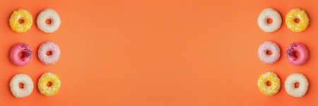 Many sweet donuts on orange background with space for text
