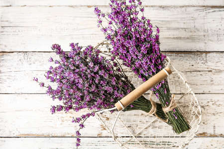 Basket with beautiful lavender flowers on light wooden background