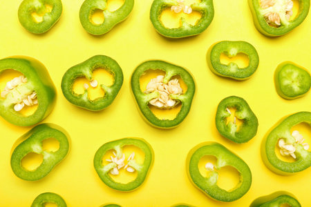 Slices of green jalapeno peppers on color backgroundの写真素材