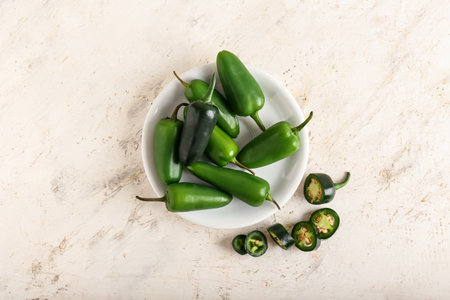 Plate with green jalapeno peppers on light backgroundの写真素材