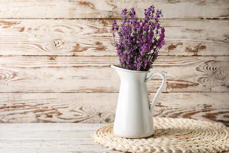 Jug with beautiful lavender flowers on light wooden backgroundの写真素材