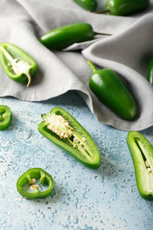 Cut green jalapeno peppers on color backgroundの写真素材