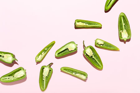 Cut green jalapeno peppers on color backgroundの写真素材