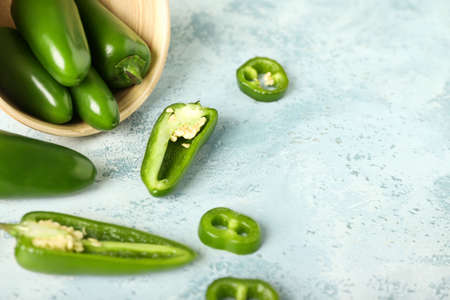 Bowl with cut green jalapeno peppers on color background, closeupの写真素材