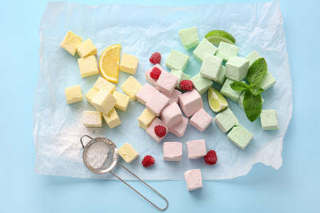 Tasty sweet marshmallows, mint and fruits on color backgroundの写真素材