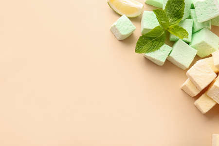 Tasty sweet marshmallows and mint on color backgroundの写真素材