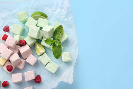 Tasty sweet marshmallows, mint and fruits on color backgroundの写真素材