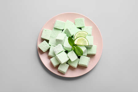 Plate with tasty sweet marshmallows on light background