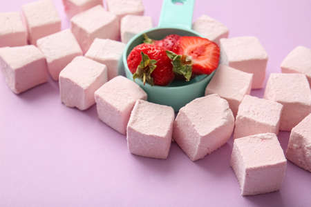Tasty sweet marshmallows and strawberries on color backgroundの写真素材