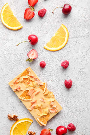 Handmade chocolate bar with fruits and berries on light background