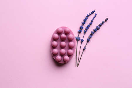 Massage soap bar and flowers on color backgroundの写真素材