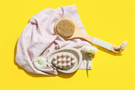 Composition with massage soap bar, brush and flowers on color backgroundの写真素材