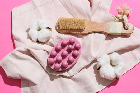 Massage soap bar, brush and cotton flowers on color backgroundの写真素材
