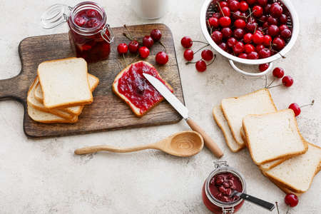 Bread with tasty cherry jam on tableの写真素材