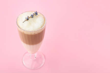 Glass of tasty lavender latte on color backgroundの写真素材