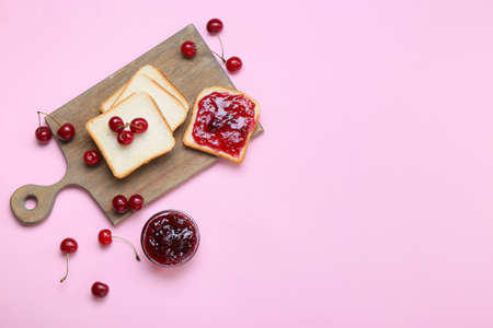 Sandwiches with tasty cherry jam on color background