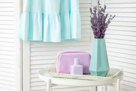 Vase with beautiful lavender flowers and female accessories on table in roomの写真素材