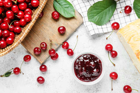 Ripe cherry and jam on light background