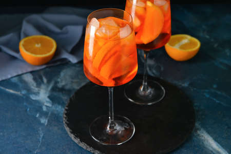 Glasses of tasty aperol spritz cocktail on color background