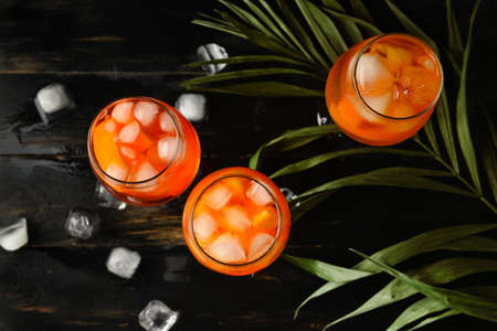 Glasses of tasty aperol spritz cocktail on dark wooden background