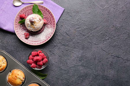 Plate with tasty raspberry muffin on dark backgroundの写真素材