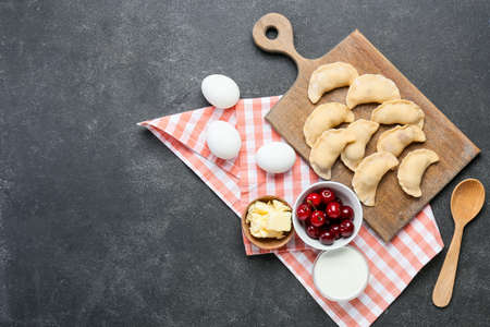 Composition with raw cherry dumplings on dark background