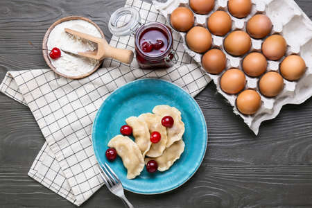 Composition with tasty cherry dumplings on dark wooden background