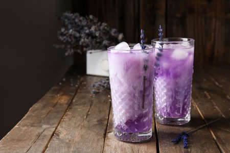 Glasses of fresh cocktail with lavender on dark wooden backgroundの写真素材