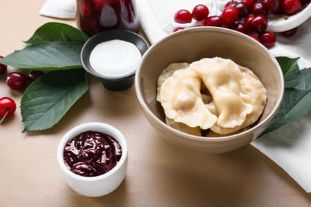 Composition with tasty cherry dumplings on color background