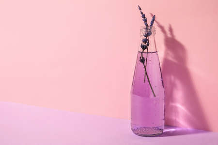 Bottle of fresh cocktail with lavender on color backgroundの写真素材
