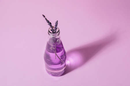 Bottle of fresh cocktail with lavender on color backgroundの写真素材