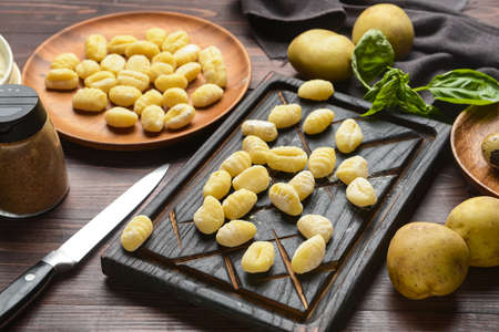 Board with raw gnocchi on wooden backgroundの写真素材