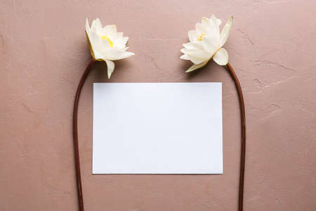 Beautiful lotus flowers and blank paper card on color backgroundの写真素材