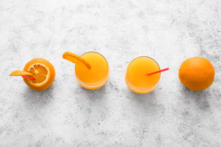 Glasses of tasty orange juice on light backgroundの写真素材