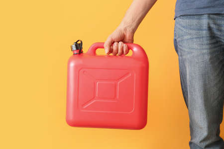 Man holding canister on color background