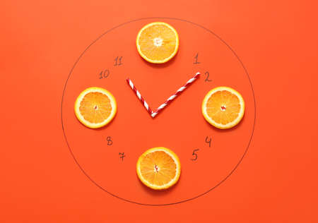 Creative composition with drawn clock and orange slices on color backgroundの写真素材