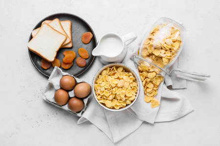 Ingredients for tasty breakfast with cornflakes on light background