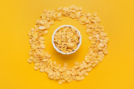 Composition with bowl of tasty cornflakes on color background